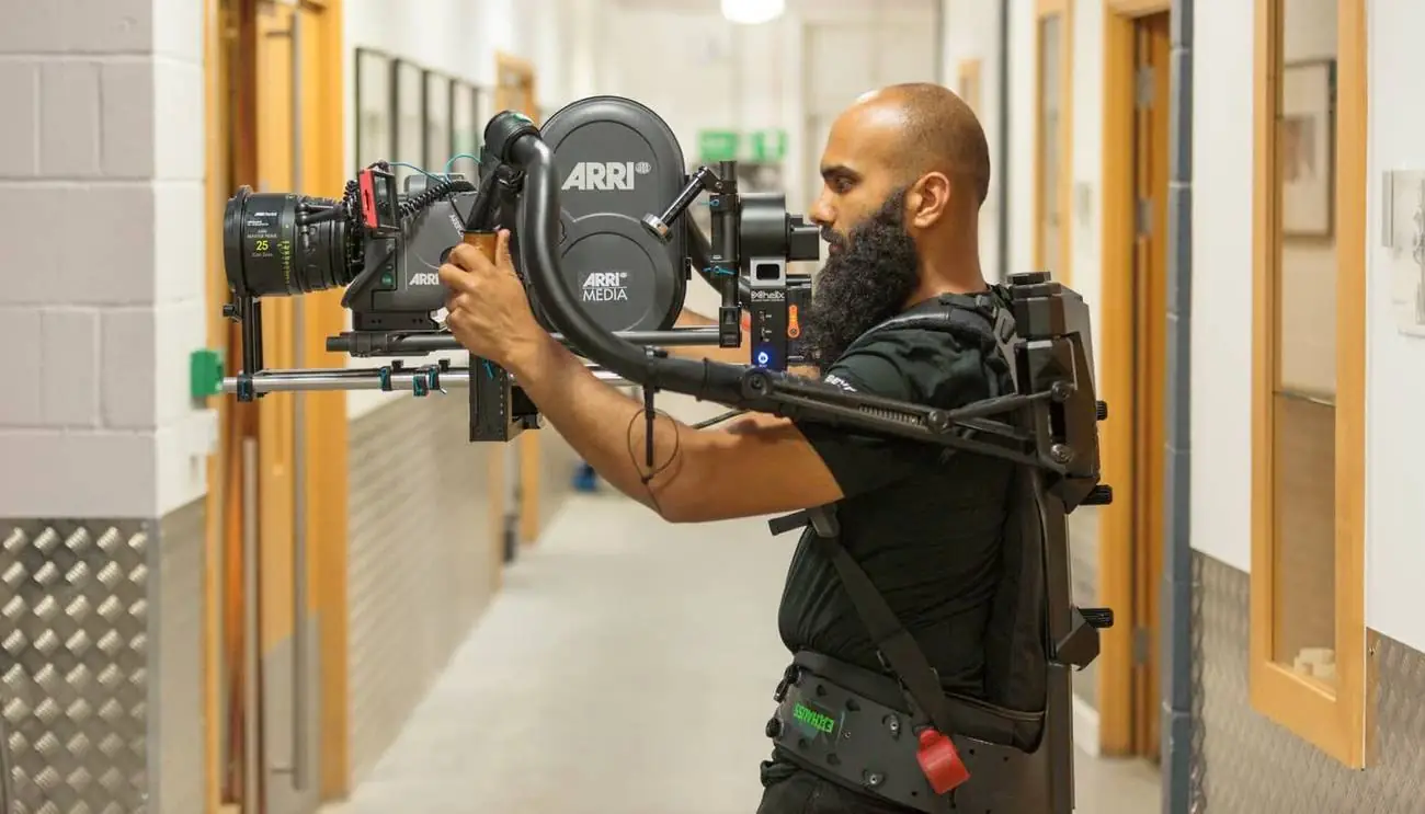 An operator carrying a camera on an exoskeleton support rig