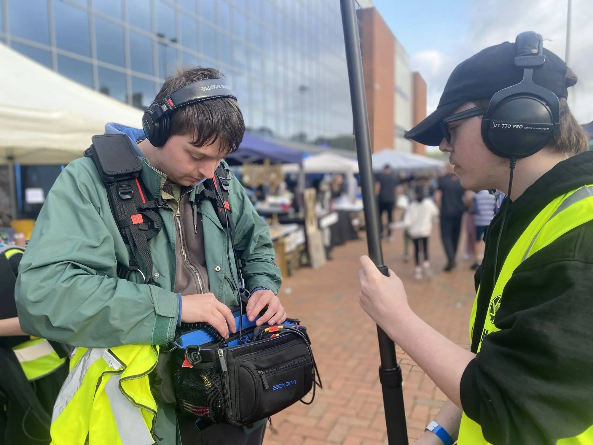 A young crew member with a sound bag in hi-vis