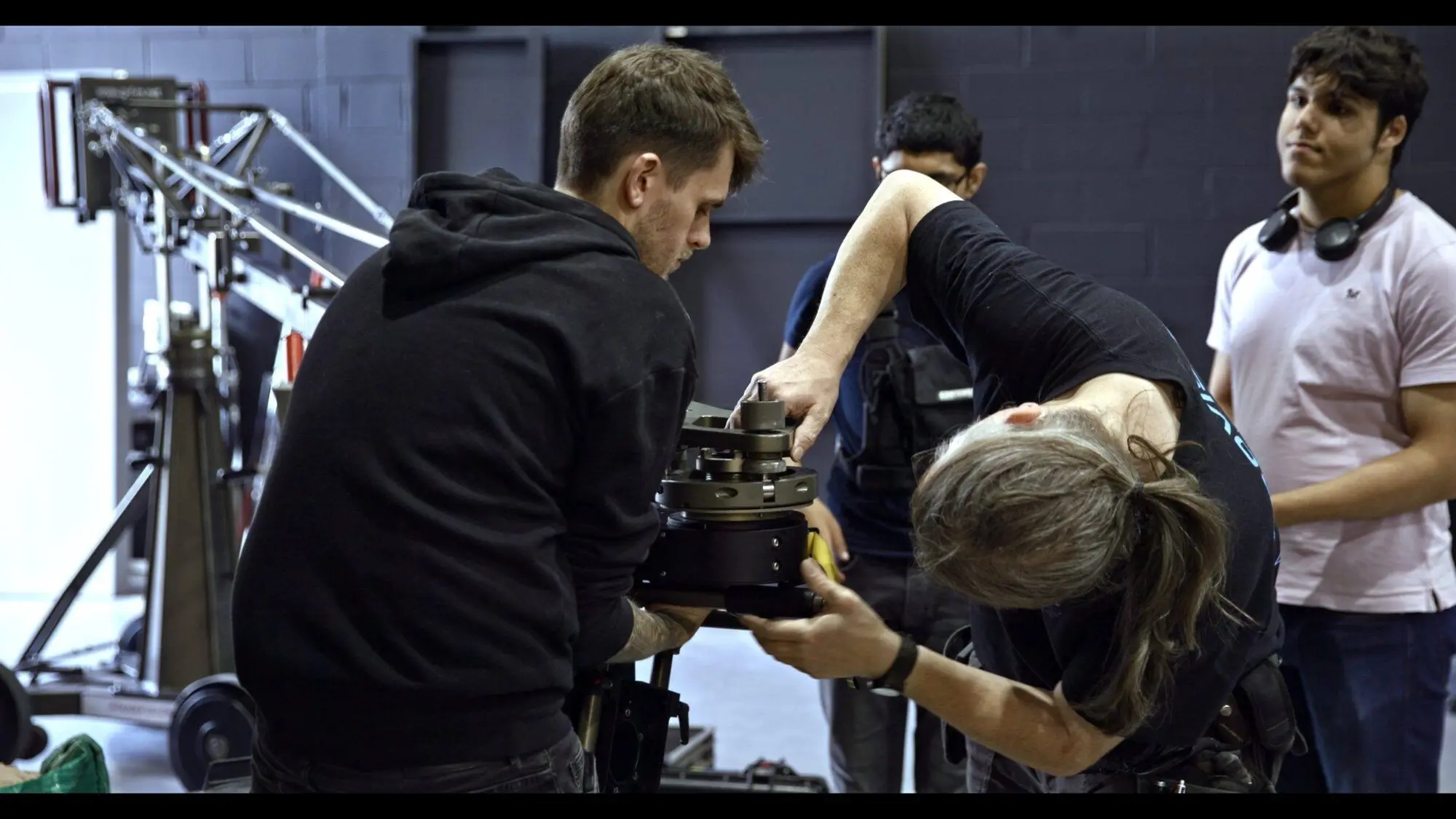 Crew at the camera on a dark stage