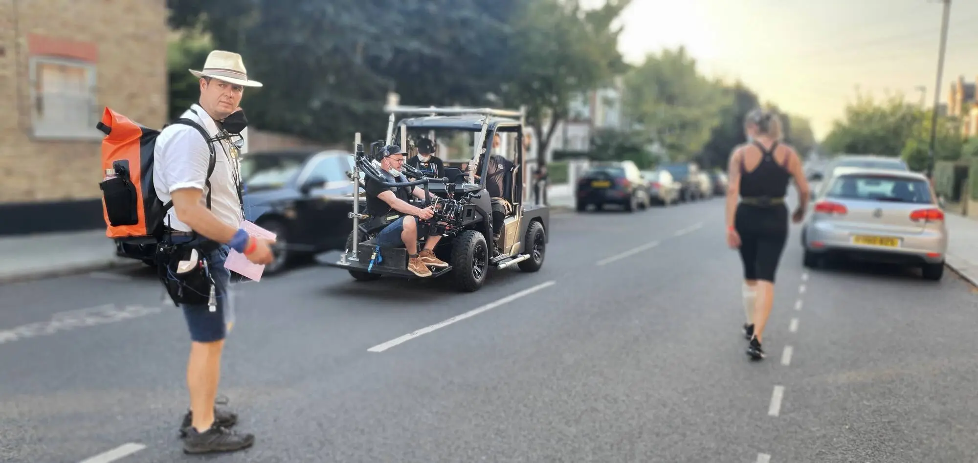 Camera car moving down a street, runner alongside