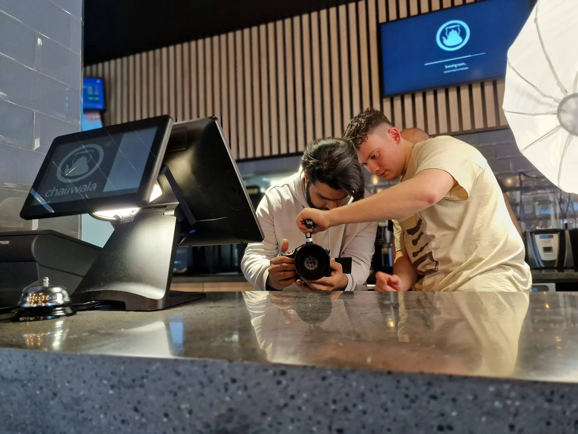 Two people over a camera on a counter